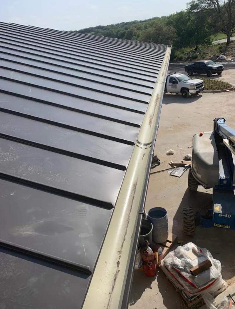 Standing seam panel and gutter detail on a metal roofing jobsite in Pearland